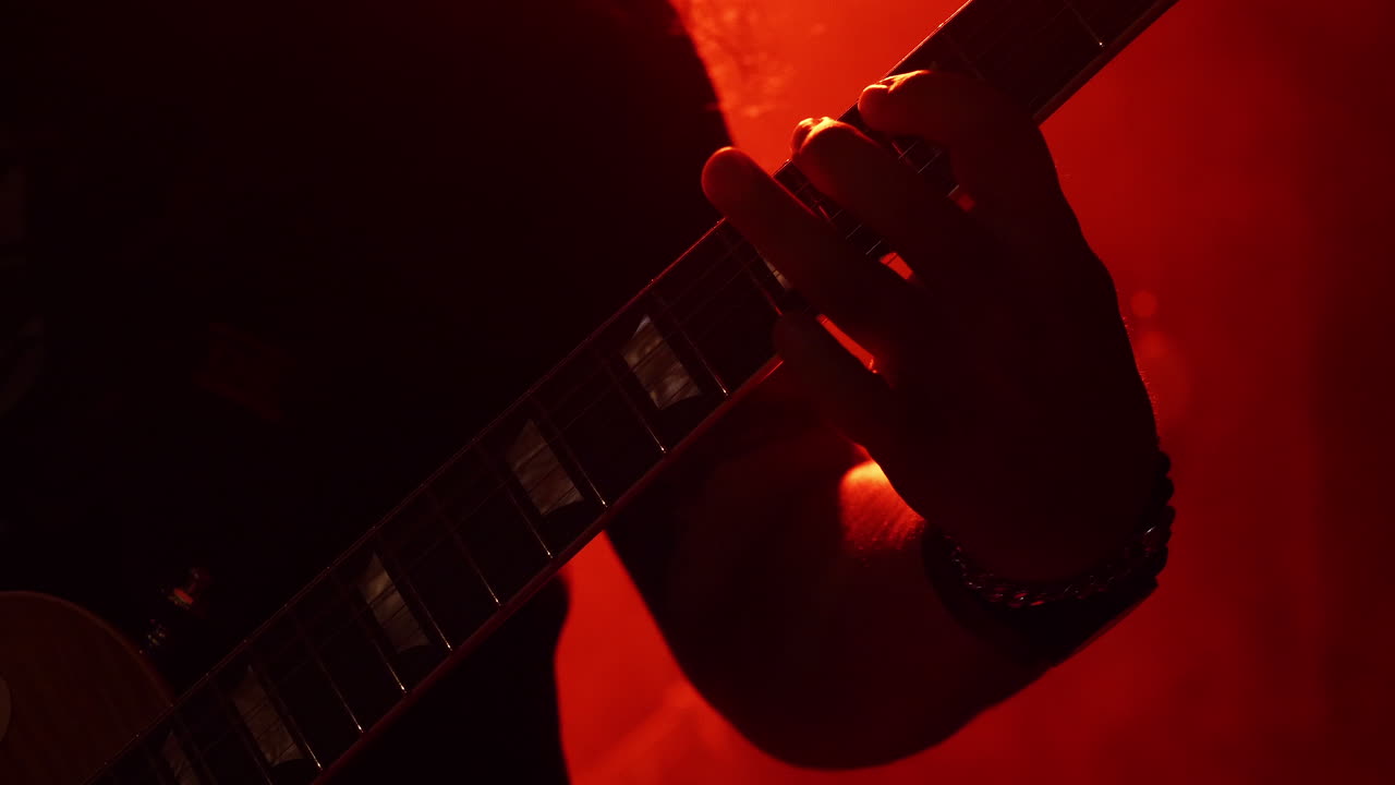 An Artist Strumming An Electric Guitar Carefully During A Concert Show - Close Up Shot
