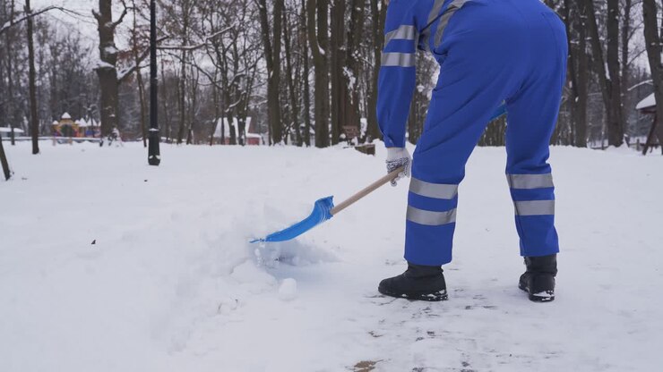 Addetto alle pulizie in incognito che rimuove la neve