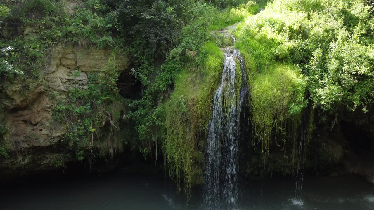 vista aérea de una hermosa cascada con un lago azul en el bosque