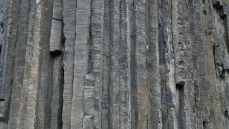 Aerial-crane-shot-climbs-tall-basalt-stone-cliff,-Garni-Canyon-Armenia