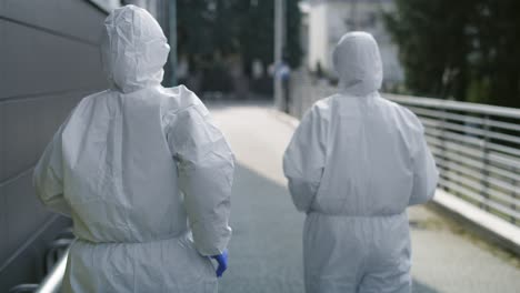 video of two technicians in clean suit in a hurry