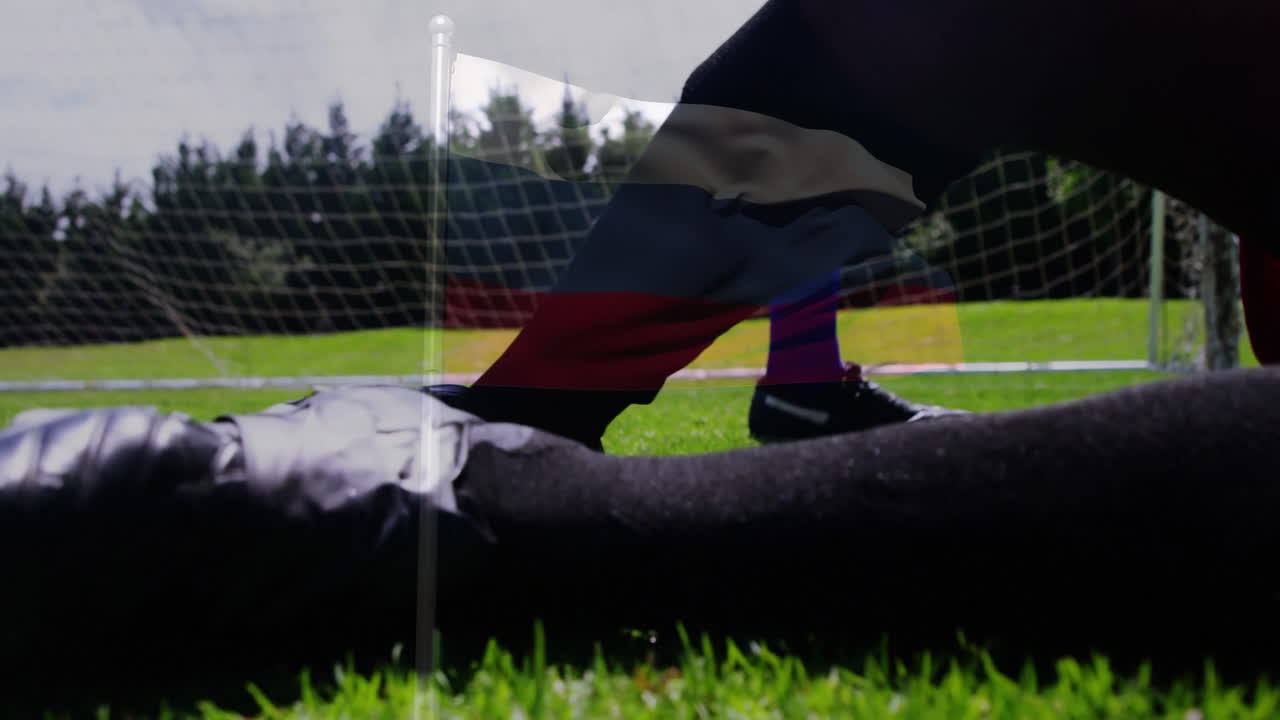 Kicking soccer ball, player on field with goal net in background