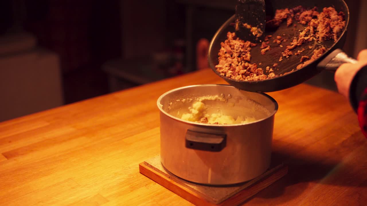 persona cubriendo el arroz en una olla con carne cocida en la cocina