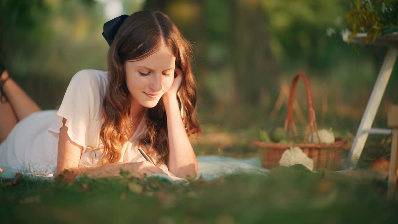 Dreamy girl lying on grass during summer