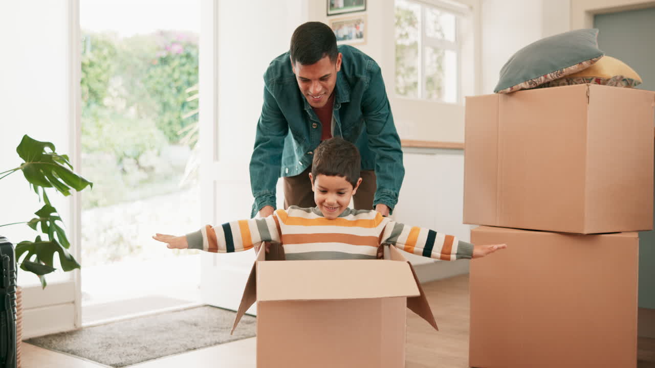 padre, hijo empujar y caja en la nueva casa para los juegos