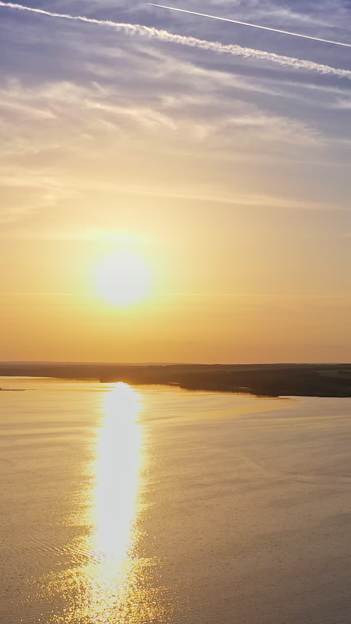 Landscape with sunset over river. Aerial view of sunset time river water horizon. Vertical video