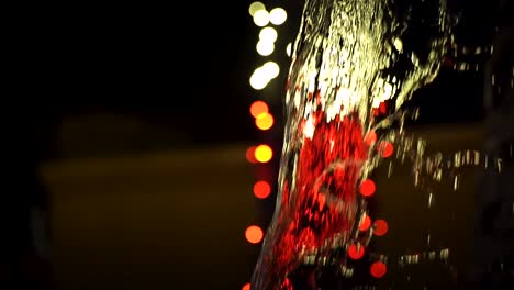 Sheets-of-Water-Falling-in-front-of-White-and-Red-String-Lights