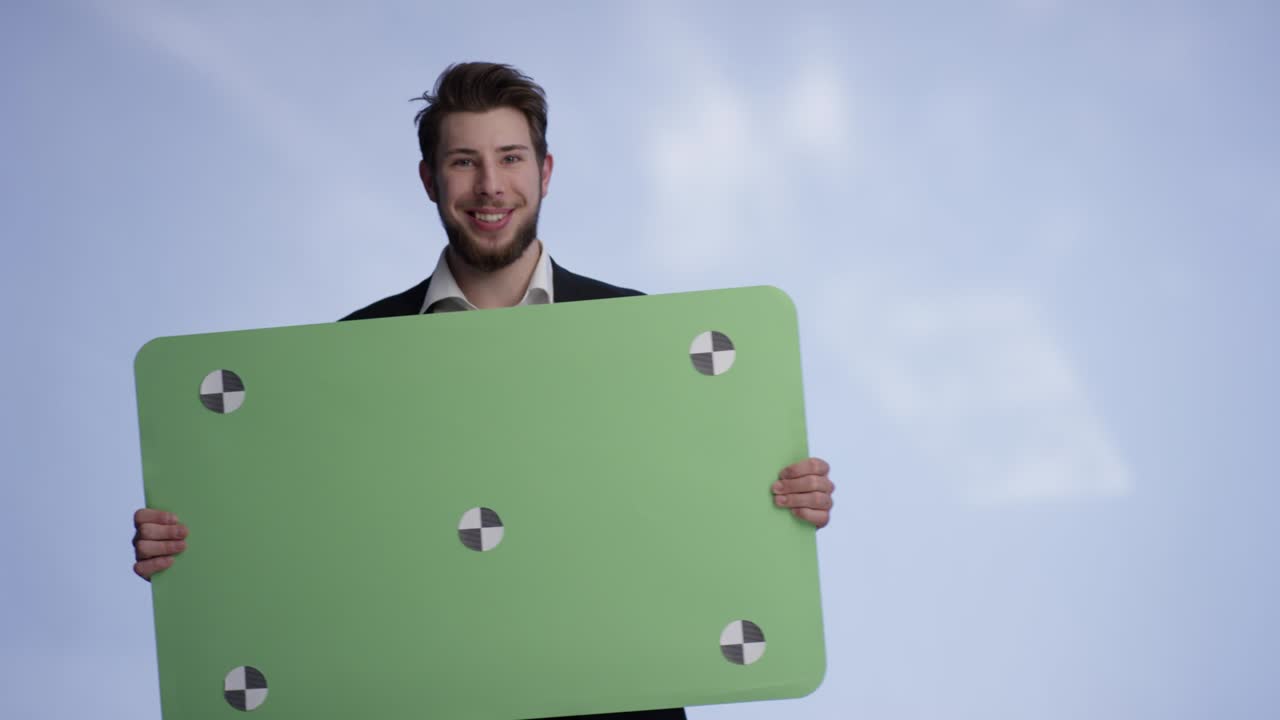 joven y confiado en sí mismo está presentando su tarjeta de promoción verde