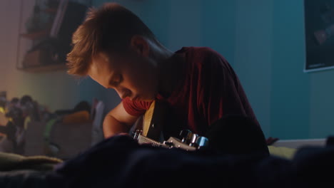 Boy Playing Guitar in Bedroom