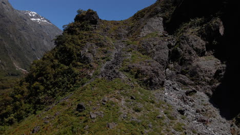 Steep-rocky-mountain-slopes-in-a-narrow-valley-in-Fiordland-Southland,-New-Zealand