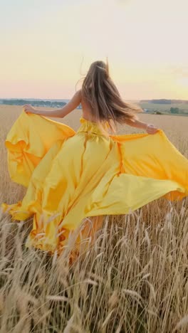 woman in yellow dress running through wheat field at sunset