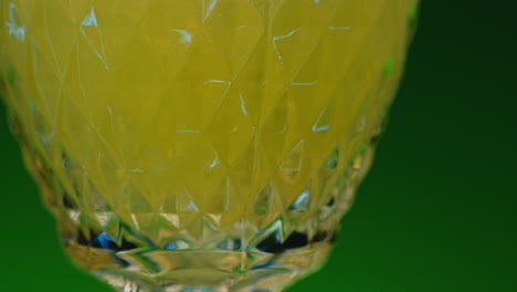 close-up of a yellow drink in a crystal glass