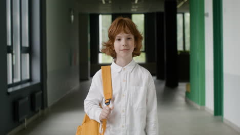 schoolboy looking at camera in school corridor.