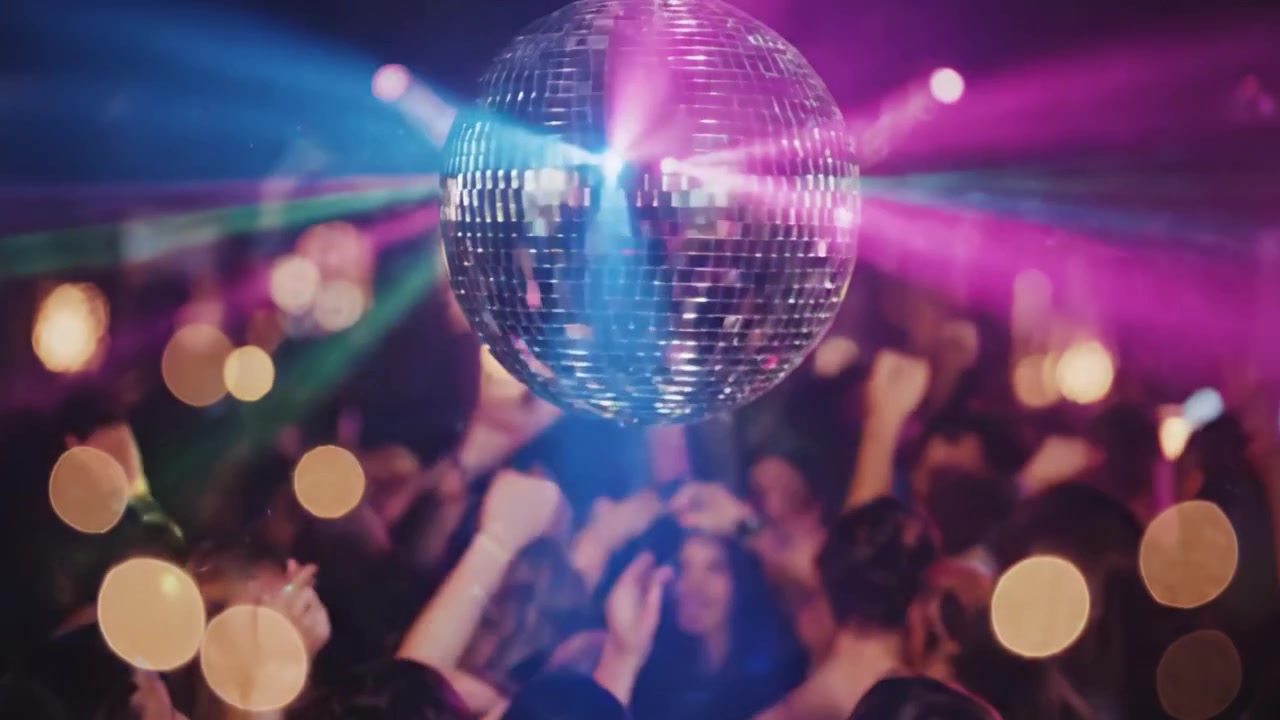 Farverig disko-scene, der indfanger den levende atmosfære under en glitrende diskokugle med lyse laserstråler og en energisk menneskemængde på dansegulvet.