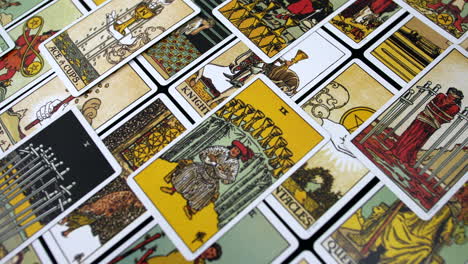 Tarot cards of the minor arcana spread out in a scattered arrangement, showcasing colorful illustrations and intricate designs symbols and themes used for divination and spiritual insight