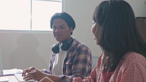 two young professionals collaborating on a project in an office setting