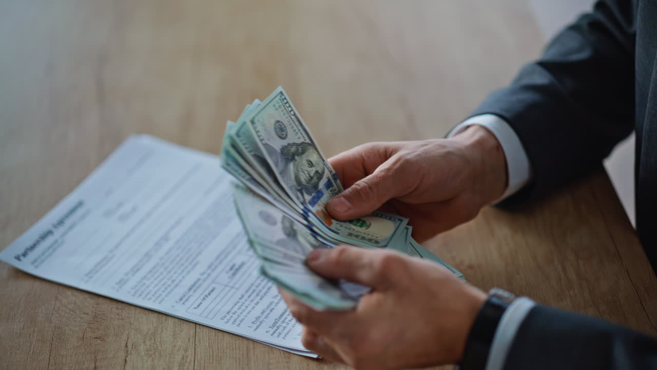 Boss hands counting salary at wooden desk closeup. Unknown man holding money
