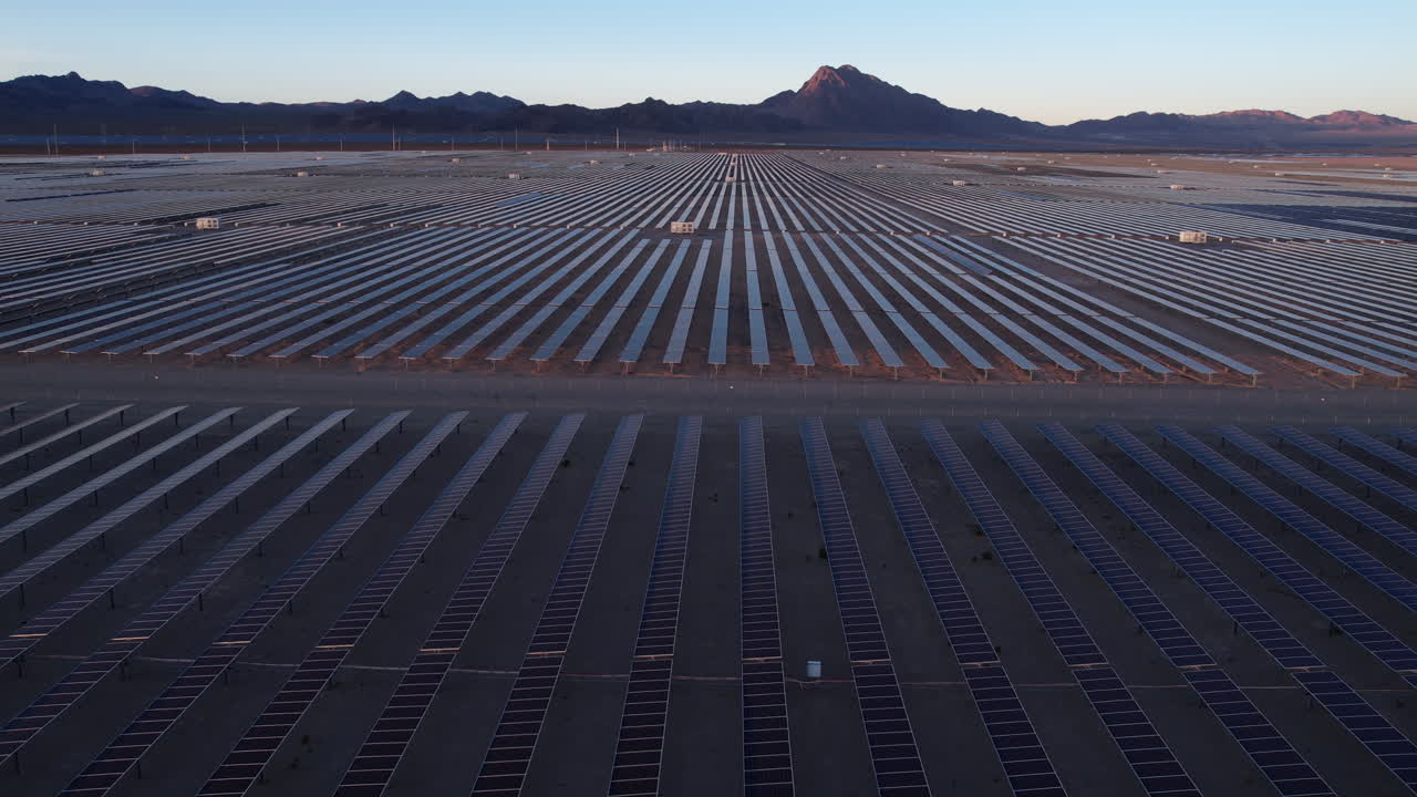 Solkraftværk, luftfoto af massive rækker af solpaneler i ørkenlandskab i skumringen, droneoptagelse