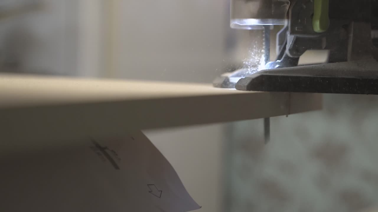 el maestro de la producción de muebles corta la superficie de la mesa con una sierra eléctrica 3