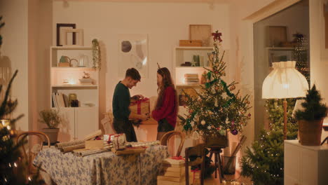 man holding christmas present standing by female friend