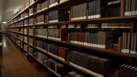 a long, quiet hallway lined with wooden bookshelves filled with books in a library or archive