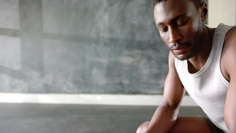 resting after workout, african american man in gym wearing tank top, looking down, copy space