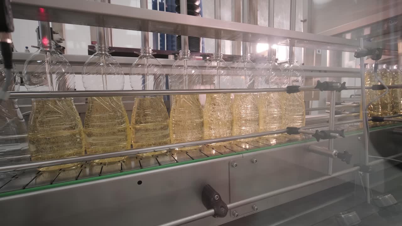 aceite de girasol en la botella que se mueve en la línea de producción. línea de embotellado de aceite de girassol en botellas. planta de producción de aceite vegetal. alta tecnología. fondo industrial