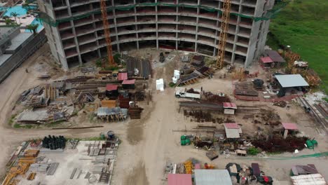 Birds-eye-view-pan-shot-of-construction-site-of-building-near-ocean-sea