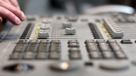 hands on a professional audio mixing console