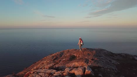 vista aérea de una mujer excursionista con una mochila haciendo senderismo en el acantilado por encima del mar y el paisaje urbano de bray en irlanda