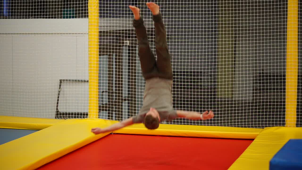 실내 트램폴린 에서 플립 을 하는 사람