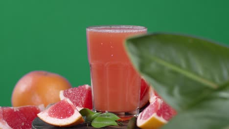 a glass of grapefruit juice slowly rotates.