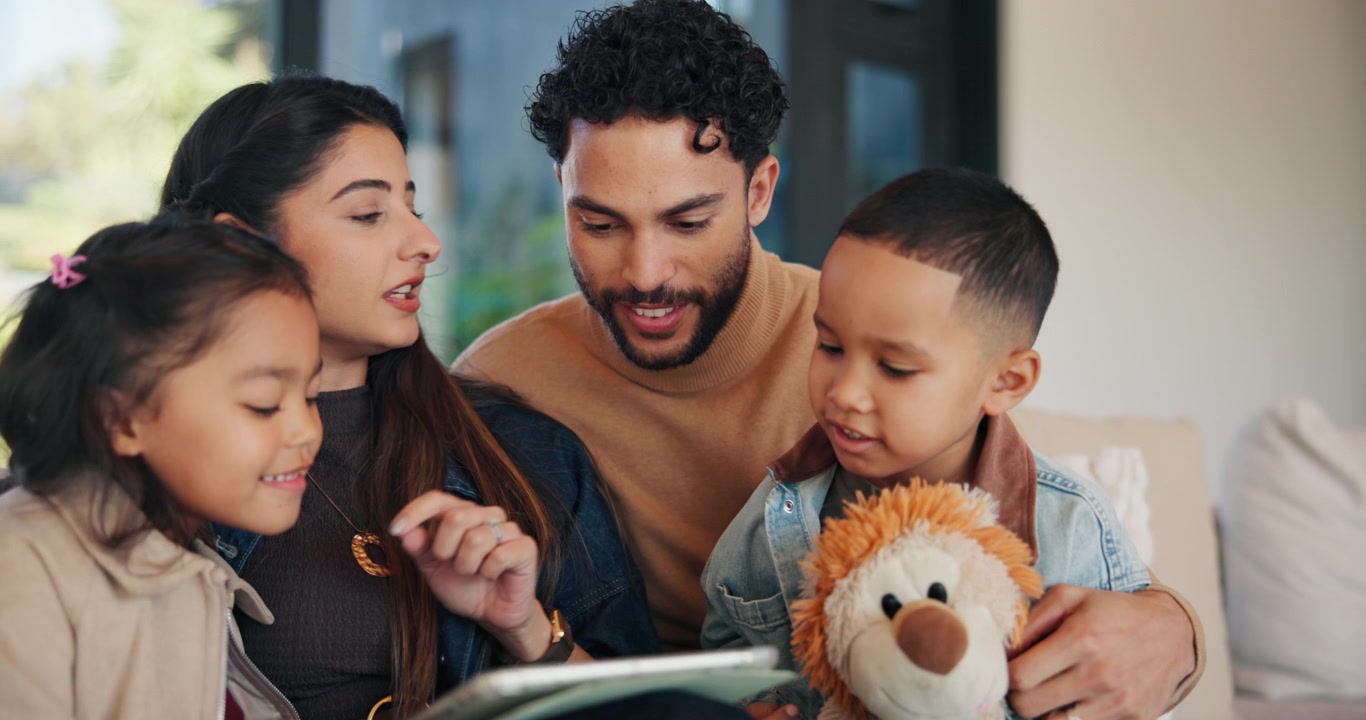 Famiglia felice che usa un tablet insieme sul divano