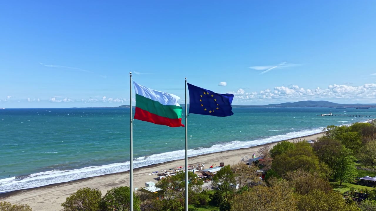 Bandiere della Bulgaria e dell'Unione Europea sventolano sulla spiaggia con il mare e il cielo sullo sfondo in una giornata di sole in Bulgaria