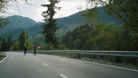 cyclists team ride bikes together on mountain road. two friends enjoy sport.