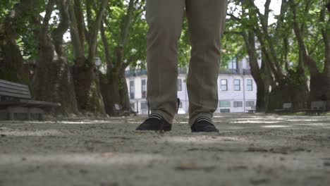 close-up shot of a man walking closer to the camera, with only the lower legs visible