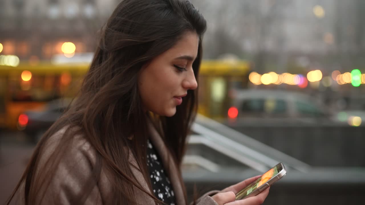 mujer usando teléfono en la ciudad por la noche