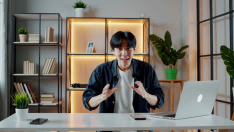asian man communicating with a laptop in an office setting