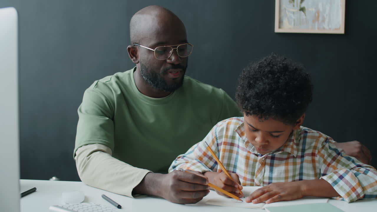 African American Father Helping Son with Doing Homework at Home