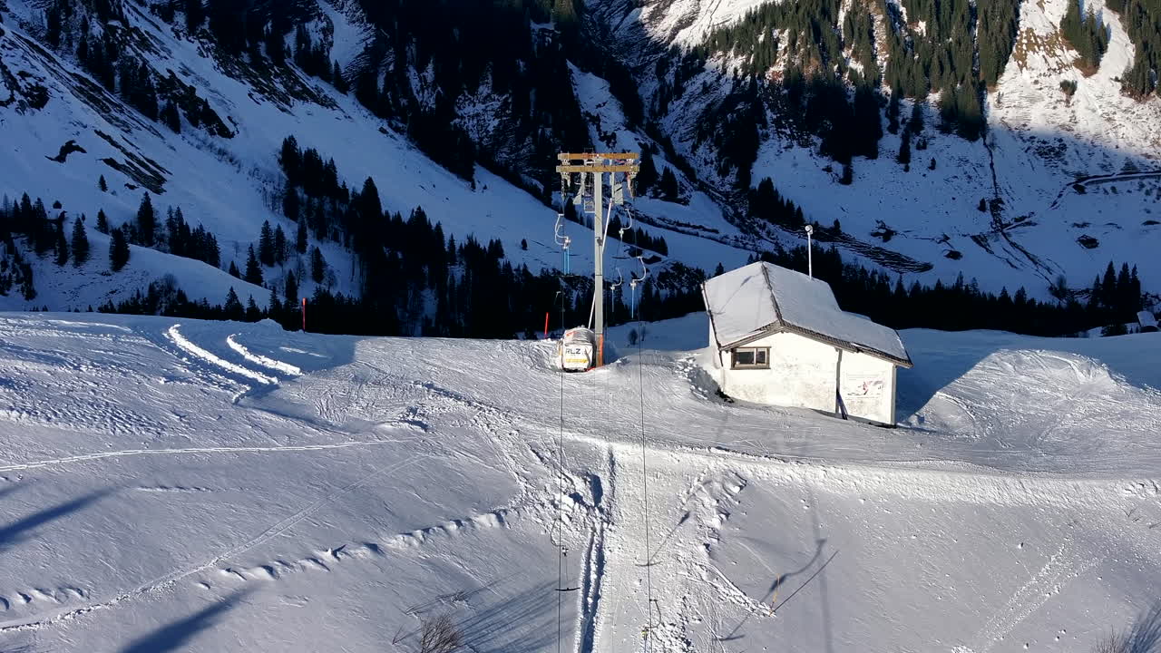zoomado en slowmo drone de inclinación de movimiento de drag ski lift en una pista de esquí en suiza