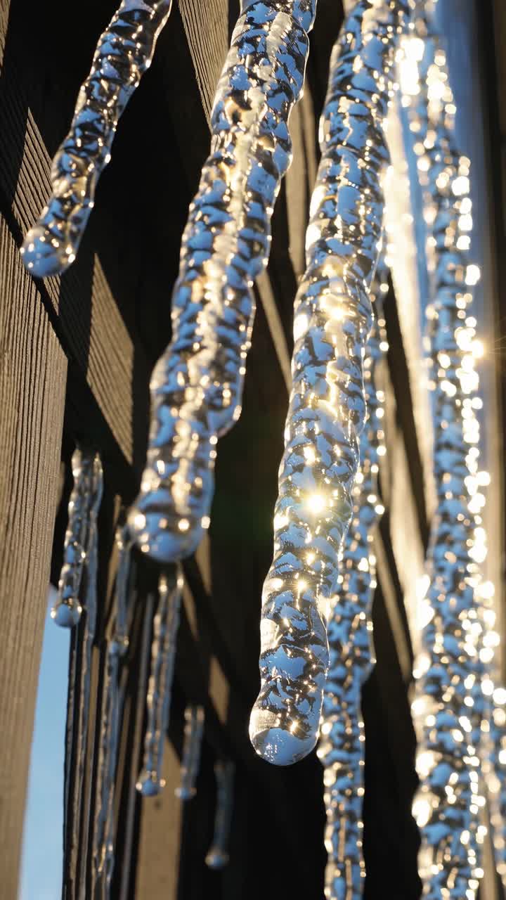 Close-up angle captures sunlight glistening through icicles on a wooden structure