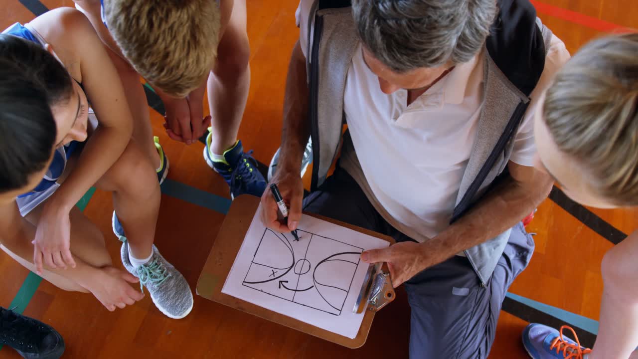 entrenador explicando el plan de juego a un estudiante de secundaria 4k