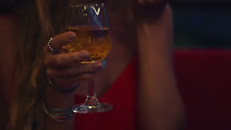 Close-up-of-woman-hands-holds-glass-of-champagne-and-eating-strawberry