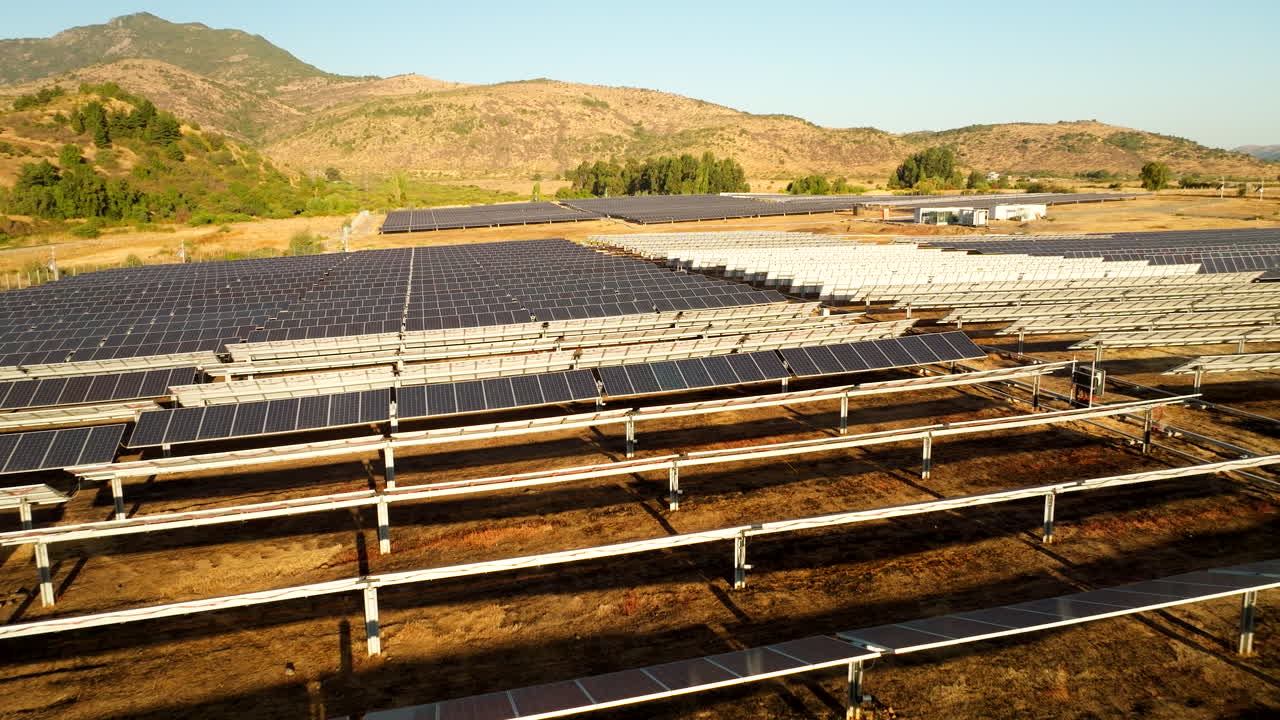 Rows of solar panels positioned at various angles at solar park in Romeral, Chile, aerial dolly