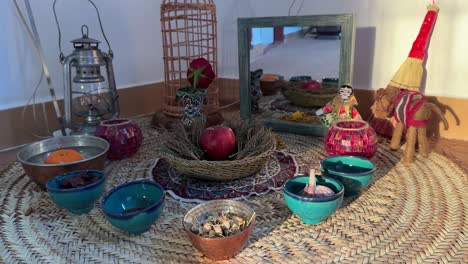 sombra del sol en una ceremonia ritual tradicional haftsin mesa de madera de mimbre espejo muñeca sumac naranja tazón de agua linterna religiosa vela hecha a mano artesanía por la gente local arte tradicional de irán