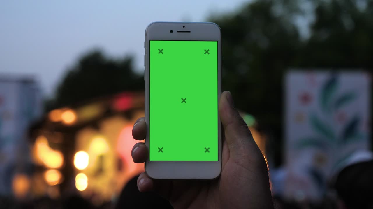 hombre con un teléfono inteligente grabando un video en un festival