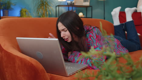 caucasian young woman use laptop surprised by bad news fortune loss fail lottery results at home