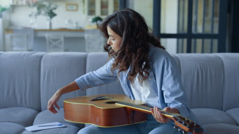 girl creating song on guitar. guitarist playing chords on string instrument