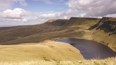 Zeitraffer-Des-Ländlichen-Sees-Im-Brecon-Beacons-Nationalpark-Und-Gelbe-Berge-Mit-Wolkenlandschaften-In-Bewegung