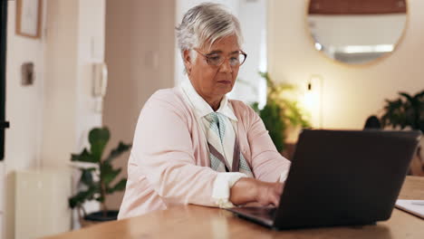 senior woman working on laptop at home